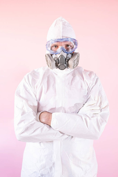 Portrait of male nurse wearing protective suit and work clothes, putting on protective goggles and mask - Фото, зображення