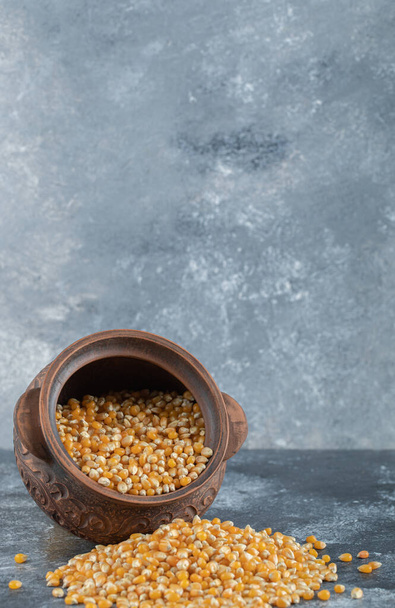 Eine alte Schüssel voller ungekochter Popcorn-Samen - Foto, Bild
