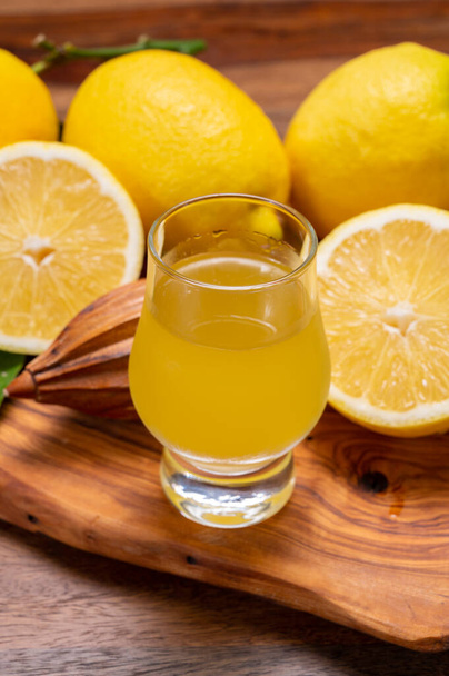 Стакан ледяного холодного сладкого лимонно-виолончельного ликера из нового урожая спелых желтых итальянских лимонов, побережье Амальфи, Италия - Фото, изображение