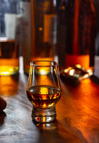 Dramen von Single Malt Scotch Whisky und Flaschen im Hintergrund, Nahaufnahme - Foto, Bild