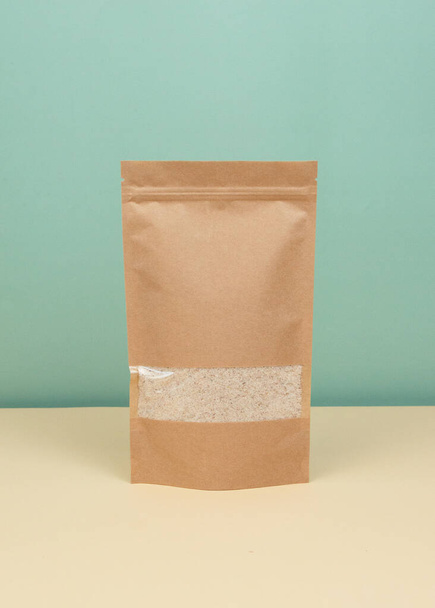 Brązowe torby papierowe typu doypack z widokiem na sklep spożywczy na żółtym tle. Opakowania dla żywności i towarów szablon makieta. Opakowania z oknami do ważenia produktów. - Zdjęcie, obraz