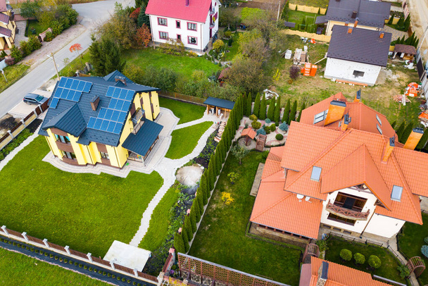 Letecký pohled na venkovský soukromý dům se solárními fotovoltaickými panely pro výrobu čisté elektřiny na střeše. Autonomní domácí koncept. - Fotografie, Obrázek