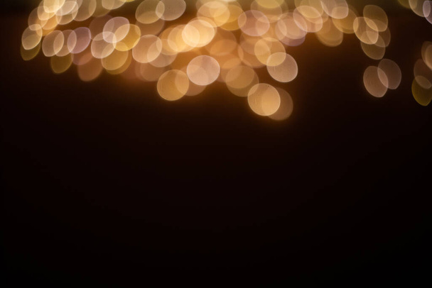 Siyah arkaplandaki altın soyut bokeh, parlak ışıklar - Fotoğraf, Görsel