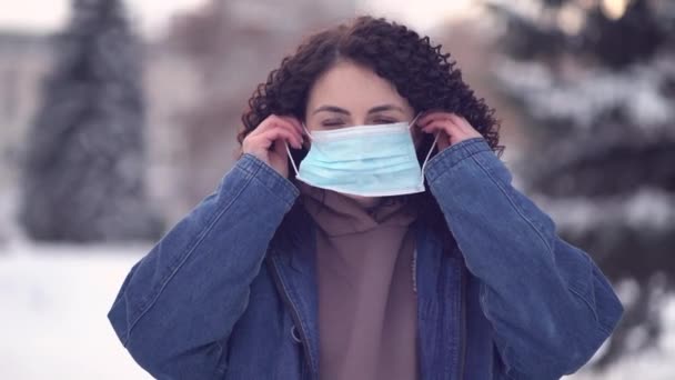 Ładna kobieta w mieście w masce chroniącej przed rozprzestrzenianiem się wirusa choroby SARS-CoV-2 - Materiał filmowy, wideo