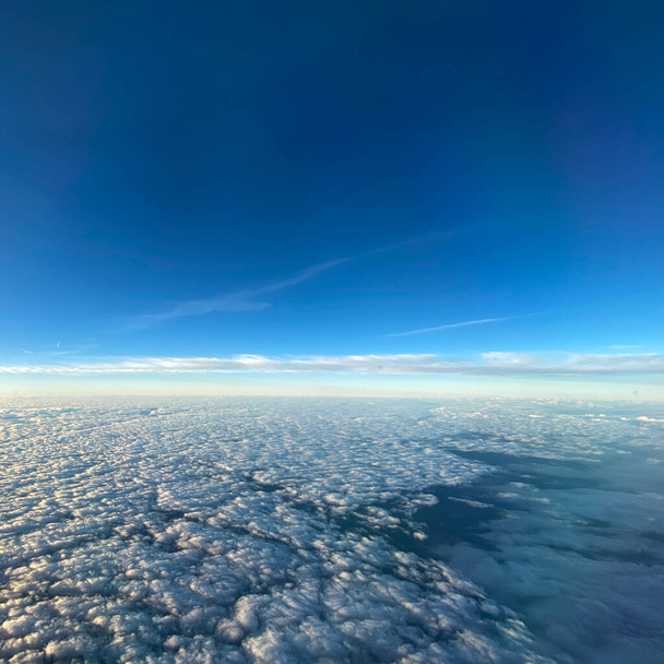 青い空の雲の飛行機の窓からの空の景色. - 写真・画像