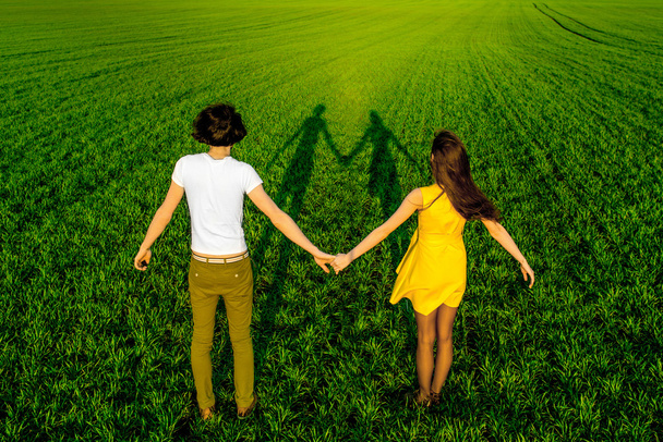 Young couple having fun on the green field in the spring or summ - Photo, Image