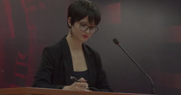 Mujer joven firmando documentos en la sala de conferencias - Metraje, vídeo