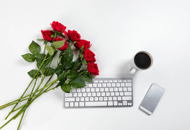 Belle rose rosse sul desktop di lavoro per un concetto di romanticismo come San Valentino - Foto, immagini