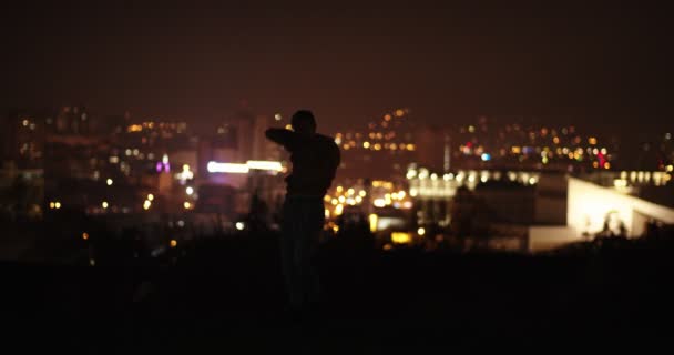 Slow motion of male dancer dancing in front of the city lights - Footage, Video