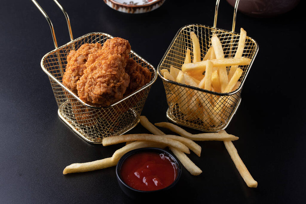 Batons de frango fritos em uma cesta em um fundo preto - Foto, Imagem