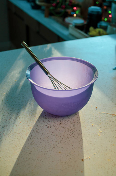 violetti sekoituskulho ja vispilä pehmeässä keittiön valossa - Valokuva, kuva