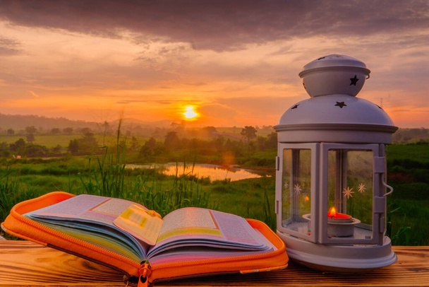 Quran, and lantern on old wood with a beautiful sunrise as background. Ramadhan Concept. - Fotoğraf, Görsel