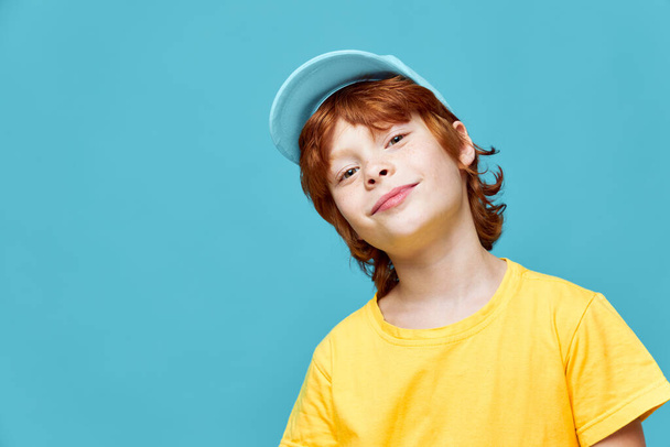 portret van een roodharige jongenskop gekanteld aan een zijde blauwe kap Copy Space - Foto, afbeelding