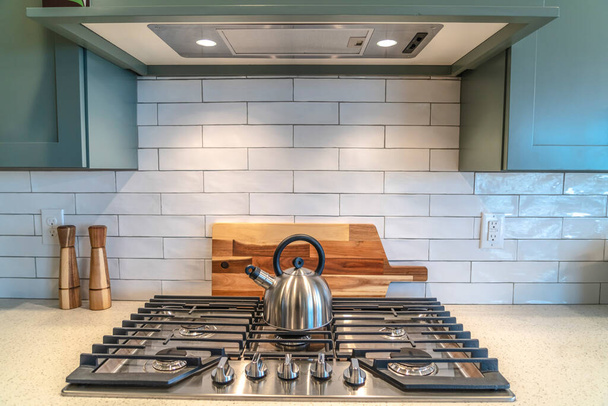 Ketel bovenop een kookplaat bevestigd aan het aanrecht in de keuken van het huis - Foto, afbeelding