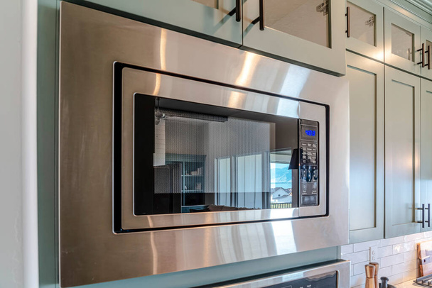 Ev mutfağında yemek ısıtıp pişiren elektrikli mikrodalga fırın. - Fotoğraf, Görsel