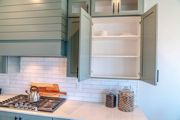 Built in cooking unit and wall cabinets inside the clean kitchen of a home - Photo, Image