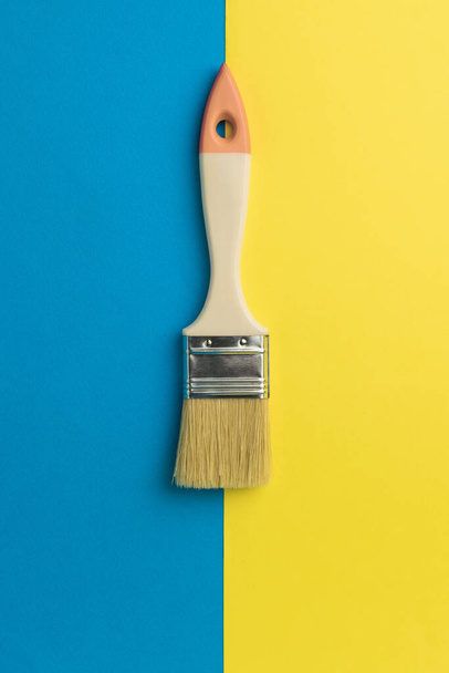 Pinsel mit einem Holzgriff am Rand von gelb und blau. Kreativ-Set. Minimalismus. - Foto, Bild
