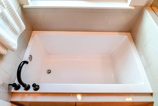 Draufsicht auf eine eingebaute rechteckige Badewanne im sauberen Badezimmer eines Hauses - Foto, Bild