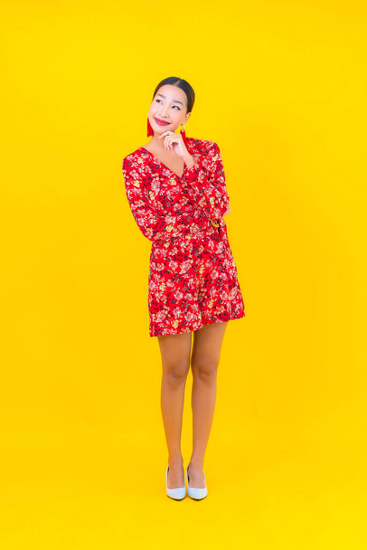 Portré gyönyörű fiatal ázsiai nő mosoly akcióban kínai újév koncepció színes háttér - Fotó, kép