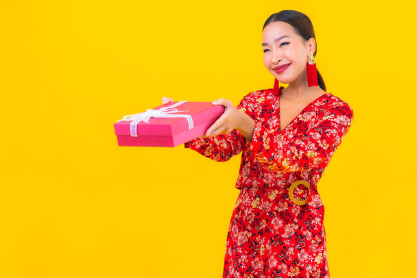 Portrait beautiful young asian woman with red gift box on color background - Photo, Image