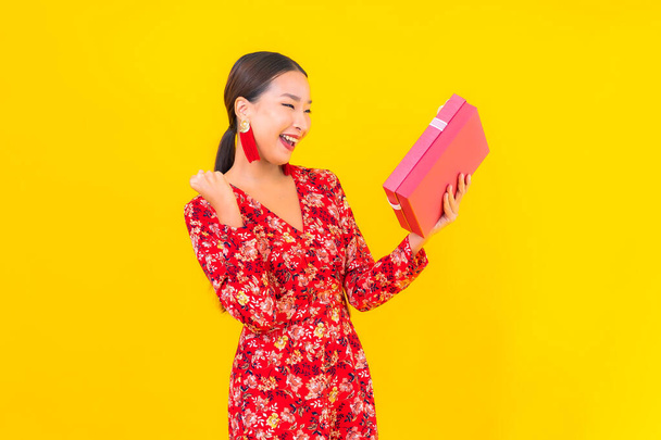 Portrait beautiful young asian woman with red gift box on color background - Foto, imagen