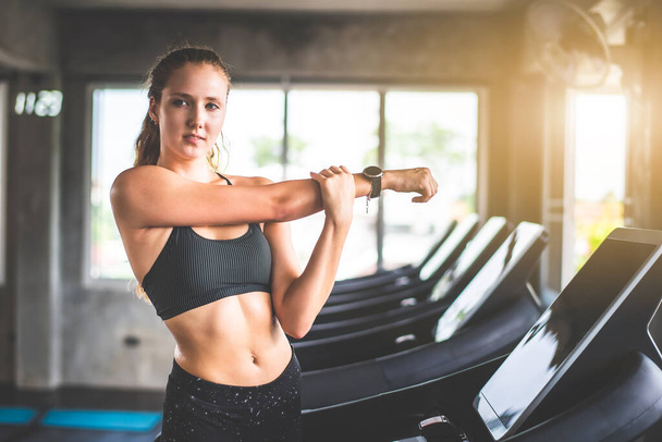 Cinematic tone of young attractive fitness woman warm up exercise before workout at gym. Individual sport to fit muscles of body for healthy life concept.  - Valokuva, kuva