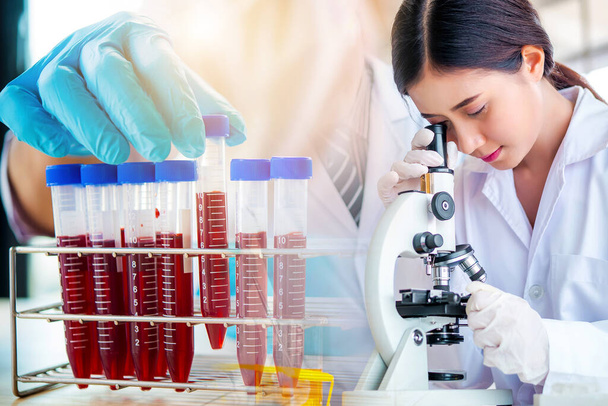 lab technician assistant analyzing a blood sample in test tube at laboratory. Medical, pharmaceutical and scientific research and development concept.  - Photo, Image