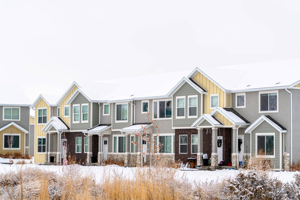 Apartments on a winter setting amidst snowy ground and cloudy white sky - Photo, Image