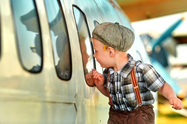 A little boy is curious about the design of the plane. The concept of choosing a future profession - Fotoğraf, Görsel
