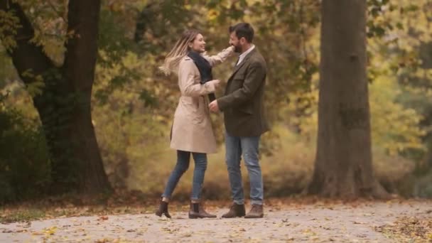 Όμορφο νεαρό ζευγάρι περπατά στο πάρκο του φθινοπώρου - Πλάνα, βίντεο