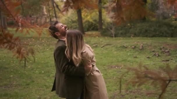 Hermosa pareja joven caminando en el parque de otoño - Metraje, vídeo