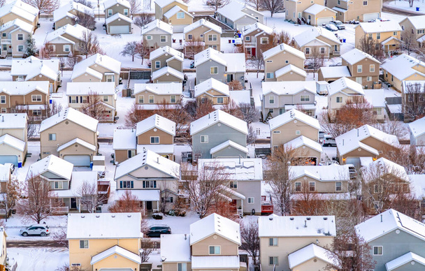 Luftaufnahme einer malerischen Stadt im Tal mit Häusern vor verschneiter Landschaft - Foto, Bild