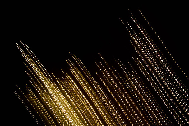líneas discontinuas doradas de luces sobre fondo negro - Foto, Imagen