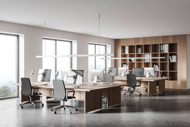 Corner of modern open space office with white and wooden walls, concrete floor and rows of computer tables. 3d rendering - Fotó, kép