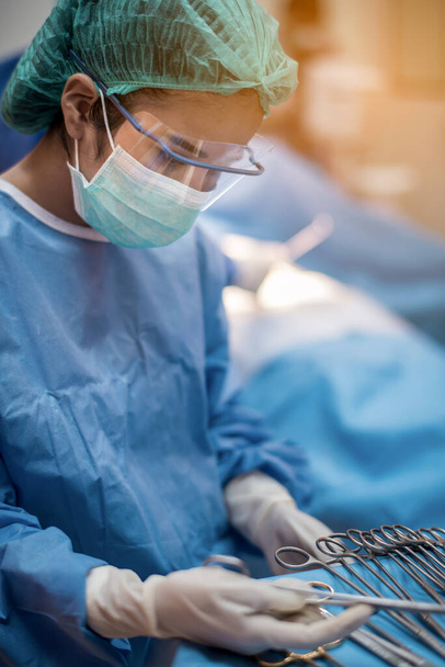 Команда врачей или хирургов в стационарной хирургии операционная скорой помощи показывает сердечный ритм пациента, во время коронавируса или ковид-19 кризиса, медицинская концепция. - Фото, изображение
