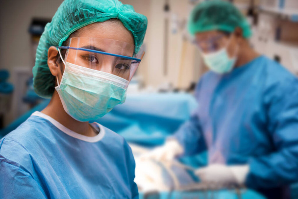 Команда врачей или хирургов в стационарной хирургии операционная скорой помощи показывает сердечный ритм пациента, во время коронавируса или ковид-19 кризиса, медицинская концепция  - Фото, изображение