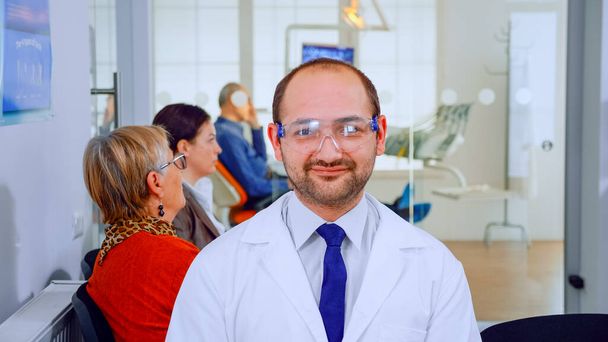 Portrait of stomatologist smiling at camera being in dental office - Foto, Imagem