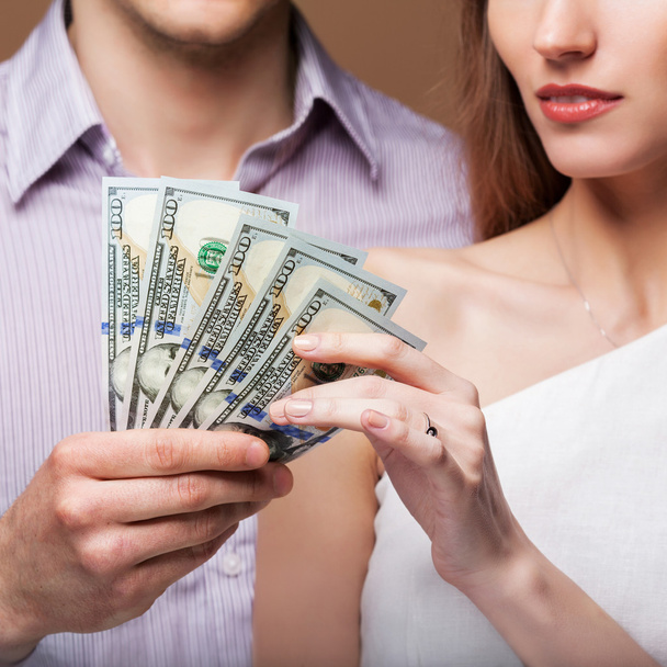 Loving couple are holding a large sum of money. - Φωτογραφία, εικόνα