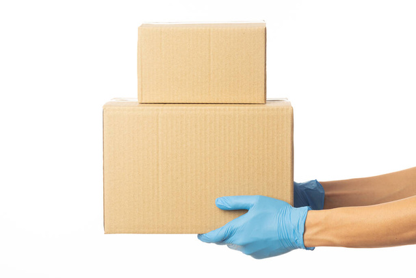 Gros plan livraison homme main dans des gants médicaux tenant des boîtes en carton isolé sur fond blanc, Modèle d'emballage, concept de service de livraison. - Photo, image
