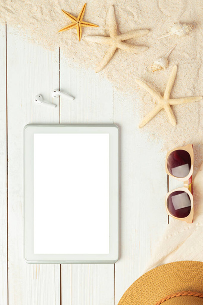 Fondo de verano con tableta de pantalla en blanco y accesorios de playa - gafas de sol sobre fondo de mesa de madera blanca vista superior con espacio para copiar. - Foto, imagen