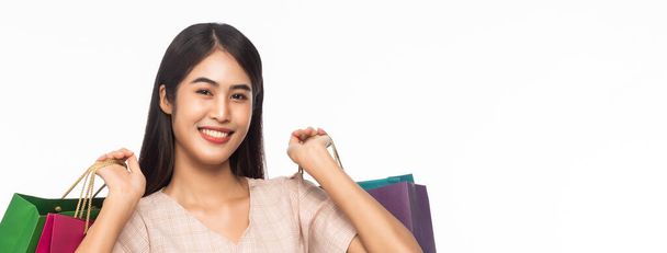 Portrét usmívající se krásné asijské ženy na sobě šaty a držení nákupních tašek izolované na bílém banneru pozadí. - Fotografie, Obrázek