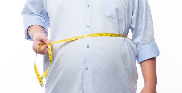 Gordo segurando uma fita métrica para conferir seu corpo isolado em fundo branco. - Foto, Imagem