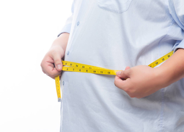 Tlustý muž drží měřicí pásku pro kontrolu jeho tělo izolované na bílém pozadí. - Fotografie, Obrázek