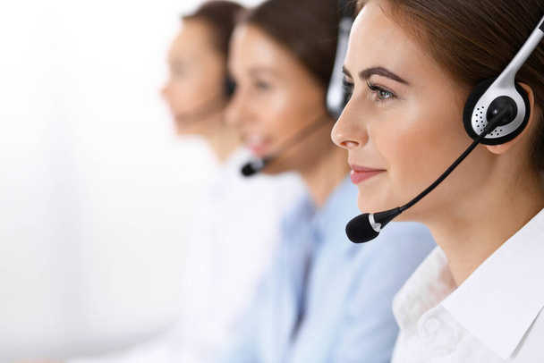 Call center. Group of operators at work. Focus on beautiful business woman in headset - Fotografie, Obrázek