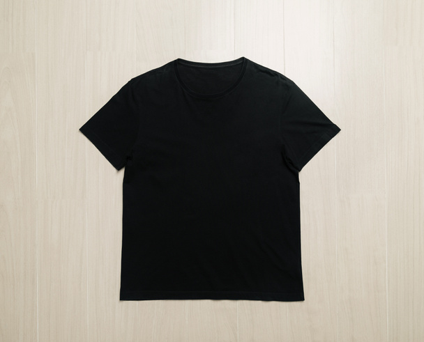 Modèle de maquette de T-shirts noirs sur sol en bois. - Photo, image
