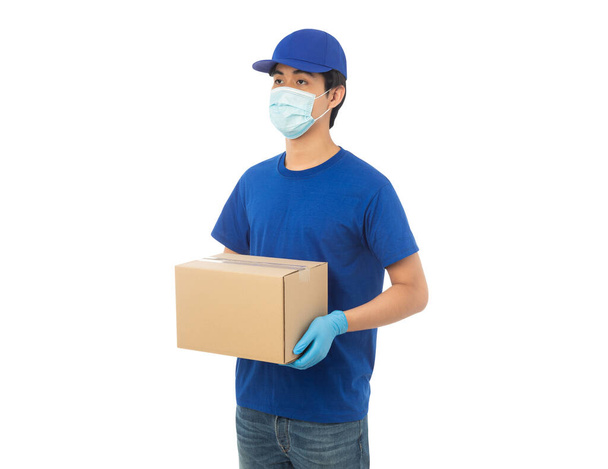 Fiatal Delivery férfi visel maszk és orvosi kesztyű tartó papír kartondoboz mockup elszigetelt fehér háttér nyírás útvonal. - Fotó, kép