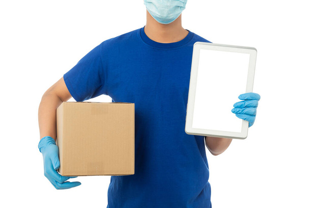 Junger Liefermann mit Maske und medizinischen Handschuhen hält Papierkarton und Tablet-Attrappe isoliert auf weißem Hintergrund mit Clipping-Pfad. - Foto, Bild