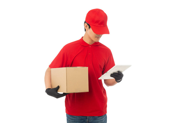 Fiatal Delivery férfi piros egyenruhában tartó papír karton doboz mockup elszigetelt fehér háttér nyírás útvonal. - Fotó, kép