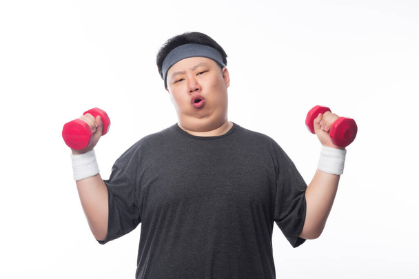 Jeune asiatique drôle gras sport homme exercice avec haltère isolé sur fond blanc. - Photo, image