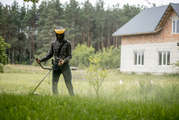 Man mowing the lawn in his garden. Gardener cutting the grass. Lifestyle - Φωτογραφία, εικόνα